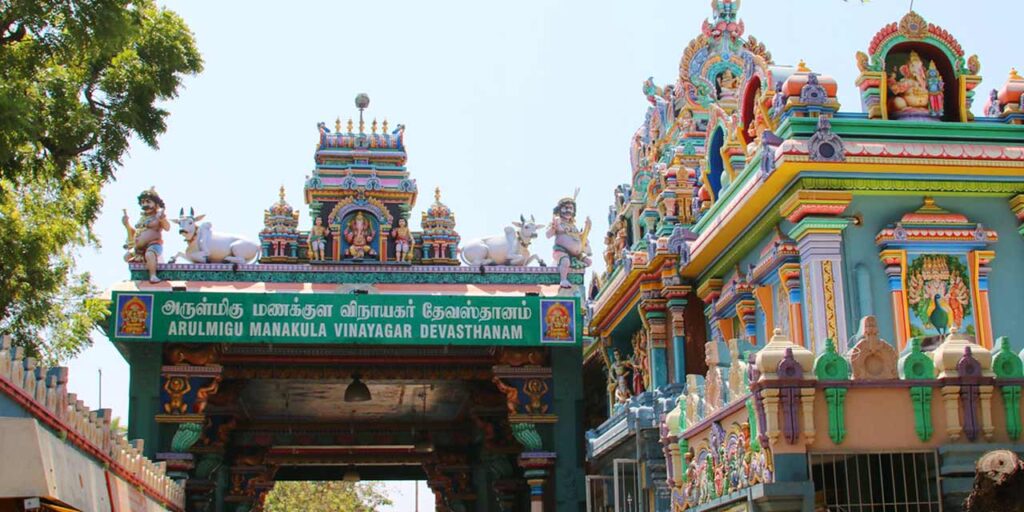 Front view of Sri Manakula Vinayagar Temple in Puducherry showing the vibrant temple tower and visitors entering.